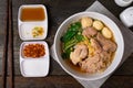 Fine cut white rice noodle in pork soup with meatball and pork in white bowl on wooden table Royalty Free Stock Photo