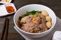 Fine cut white rice noodle in pork soup with meatball and pork in white bowl on wooden table Royalty Free Stock Photo