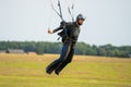 A fine day during vacation time. Many practices their favorite sport. Picture of a skydiver landing after a skydive