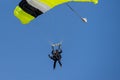 A fine day during vacation time. Many practices their favorite sport. Picture of a skydiver landing after a skydive