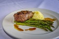 Elegantly displayed grilled ribeye steak with creamy potatoes, grilled asparagus, and au jus sauce