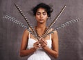 In fine feather. a stylish young ethnic woman posing with feathers in a studio.