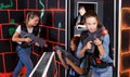 Fine girl aiming laser gun at other players Royalty Free Stock Photo