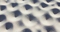 Fine-grained sand with a textured surface, featuring a pattern of small, evenly spaced shadows. The Royalty Free Stock Photo