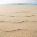 In fine, light tan sand create a textured surface, extending towards Royalty Free Stock Photo