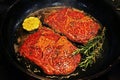 Fine marbling wagyu beef steak cooking with fresh herbs and garlic in a hot griddle Royalty Free Stock Photo