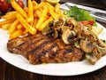 Fine Meat - Grilled Pork Neck Steak with French Fries, Onions and Mushrooms Royalty Free Stock Photo