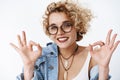 Fine it okay. Portrait of upbeat joyful and charismatic attractive young 20s girl with blond hair and glasses smiling Royalty Free Stock Photo