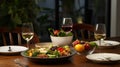 Fine restaurant dinner table place setting: napkin, wineglass, plate, bread and salad. Royalty Free Stock Photo