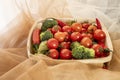 Fine wood basket with bulk ripe cherry tomatoes with broccoli chunks and red hot chili peppers Royalty Free Stock Photo