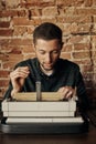 Fine young writer working on a classic typewriter. he is happy and in no hurry