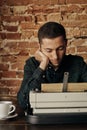 Fine young writer working on a classic typewriter. he is happy and in no hurry