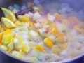 Finely chopped apples and oranges boil in a saucepan with cinnamon stick and spices Royalty Free Stock Photo