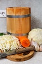 Finely chopped cabbage prepared for pickling. Wooden barrel and cutting board with a knife on the table Royalty Free Stock Photo