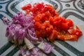 Finely chopped onions and tomatoes on the chopping table with selective focus