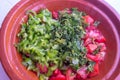 Finely chopped tomatoes, green peppers and parsley in a brown bowl Royalty Free Stock Photo