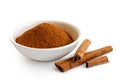Finely ground cinnamon in white ceramic bowl isolated on white. Royalty Free Stock Photo