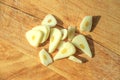 Finely sliced garlic on a wooden board with slanted shadows.