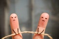 Finger art of couple. Woman and man pull rope.