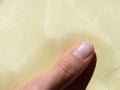 Finger on bulletproof material aramid. Shining aramid kevlar background. Yellow kevlar texture and pattern Royalty Free Stock Photo