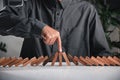 Finger of businessman pointing one wooden to stopping domino effect stopped Royalty Free Stock Photo