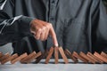 Finger of businessman pointing one wooden to stopping domino effect stopped Royalty Free Stock Photo