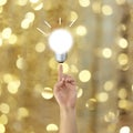 finger of a businessman pointing to a light bulb on bokeh background. Royalty Free Stock Photo