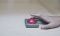 finger extended Press the red button on wood table. Royalty Free Stock Photo