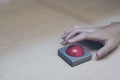 finger extended Press the red button on wood table. Royalty Free Stock Photo