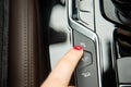 The finger of a female hand points to the parking assistant button, the equipment of a modern car. close-up, soft focus Royalty Free Stock Photo