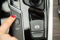 The finger of a female hand hush to the parking assistant button, the equipment of a modern car. close-up, soft focus Royalty Free Stock Photo