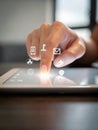 Finger gently tapping tablet screen with glowing UI icons, close-up gesture shot in soft ambient indoor light Royalty Free Stock Photo