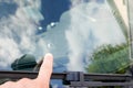 Finger hand man pointing broken windshield of a car traces of oncoming stone on road