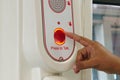 Finger hand pressing red button for emergency