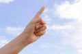 A finger and hand reaching toward the blue sky background. Royalty Free Stock Photo