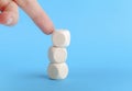Finger knocking over a small tower of three blank wooden cubes, blocks, pushing and destabilizing a built structure, balance Royalty Free Stock Photo