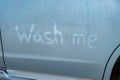 Finger lettering wash me in a dirty blue car. Royalty Free Stock Photo