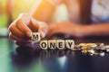 Finger pick word `M`. wood cube word `money` near coin