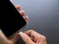 Finger plugging a charger Mobile on Black wood background