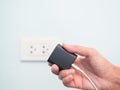 Finger Plugging a Charger Mobile on Green wall background