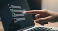 Finger pointing at checklist on laptop screen with green checkmarks to do list task Royalty Free Stock Photo