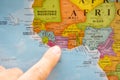 Finger pointing to a colorful country map in English and French Ivory Coast Cote D`Ivoire