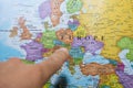 Finger pointing to a colorful country map of Europe deciding which country to vacation and travel