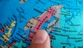 Finger pointing to the country of Sweden on a Globe