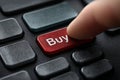 Finger presses buy button on computer keyboard Royalty Free Stock Photo