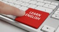 Finger presses a red learn English button on a white keyboard. Online education and language learning concept for foreign language Royalty Free Stock Photo