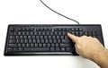 Finger pressing Backspace button on the black keyboard