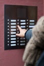 Finger pressing door bell at apartment building