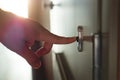 Finger pressing doorbell in sunny apartment building Royalty Free Stock Photo