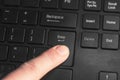 A finger pressing the `Enter` key on the black keyboard Royalty Free Stock Photo